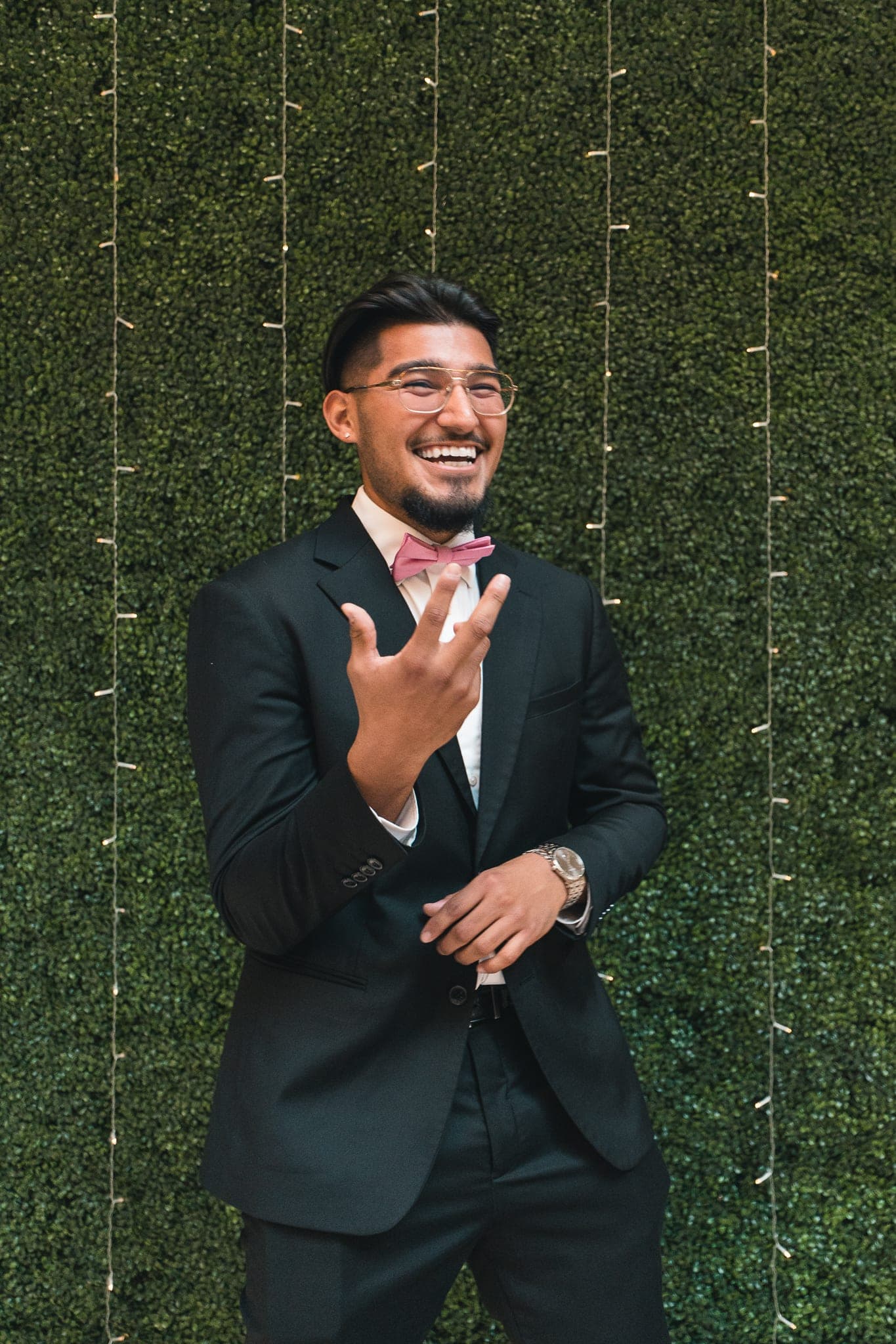 Rep in black suit + bow tie, laughing